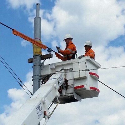 Two workers maintain power lines, underscoring the role of Succession Planning in technical fields.