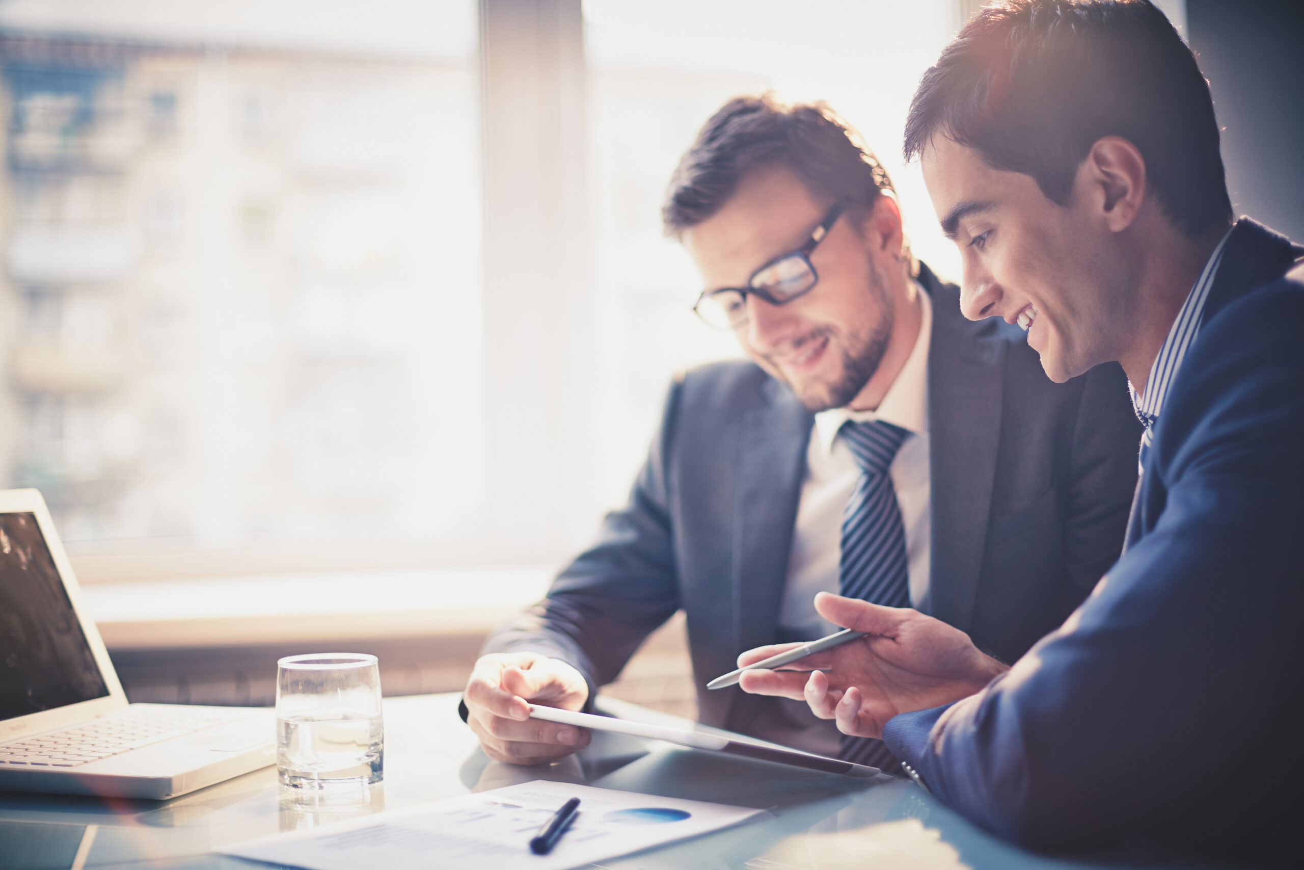 Image,Of,Two,Young,Businessmen,Using,Touchpad,At,Meeting Businesspeople discussing for management consulting